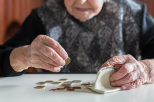 elderly woman counting coins in her wallet